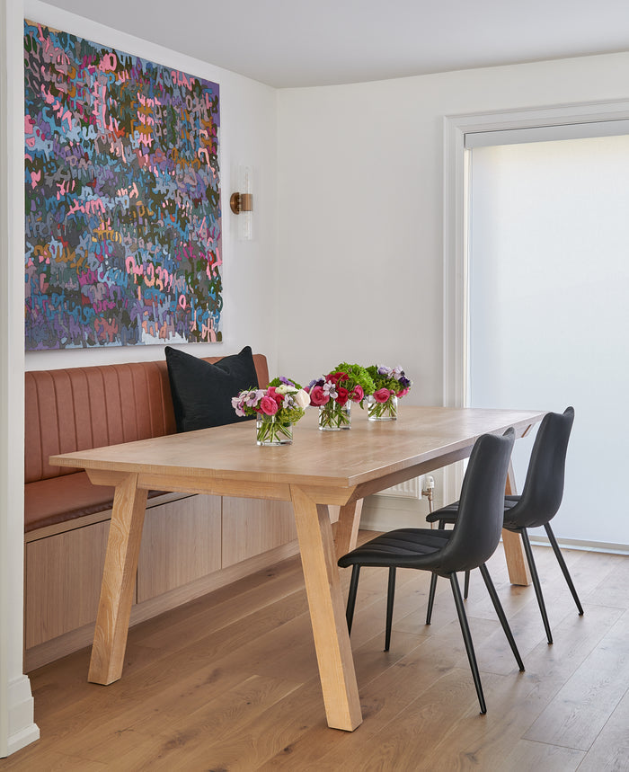 Contemporary banquette table and seating with black leather seating and modern art